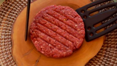 Cook göğsü hamburger için iki spatula ile yükseltir.