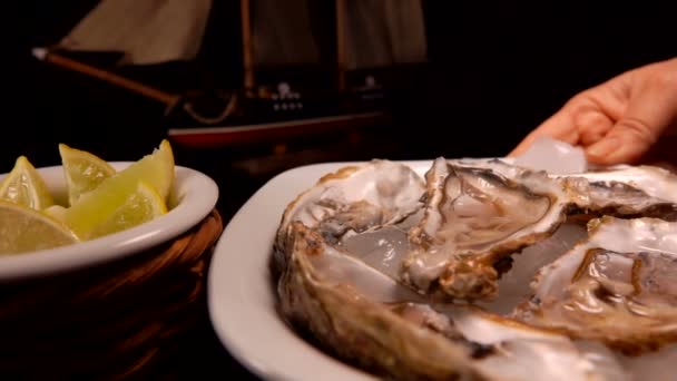 Plaat van oesters op ijs wordt op de tafel geplaatst. — Stockvideo