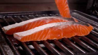 Cook Çiğ somon fileto ızgara ızgara koyar.