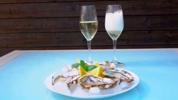 Champagne staan op tafel naast verse oesters — Stockvideo