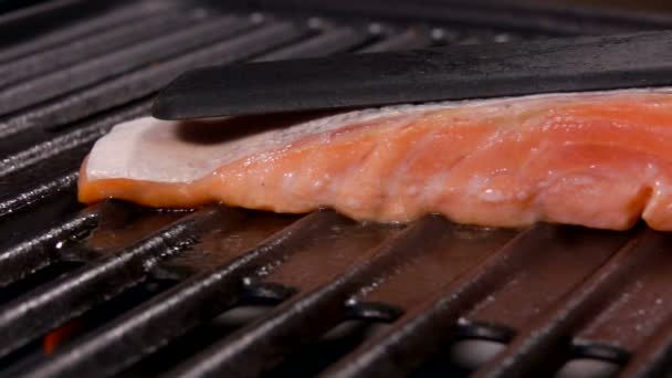 El humo se eleva por encima del salmón en la parrilla . — Vídeo de stock