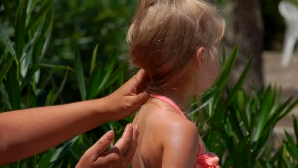 Hand uitstrijkjes beschermende crème op achterkant van het meisje — Stockvideo
