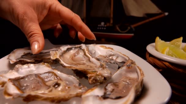 Vrouwelijke hand neemt Oyster van de plaat — Stockvideo