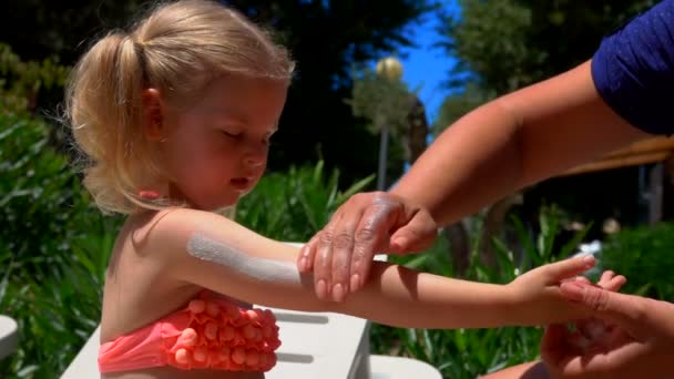 Las manchas de mano crema protectora en el cuerpo de una niña — Vídeo de stock