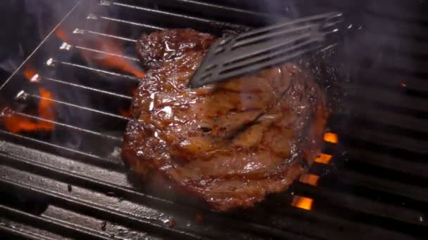 Cook stiskne steak na grilovací rošt. — Stock video