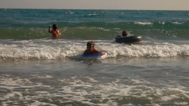 Niño pequeño se desliza en una ola en una pequeña tabla de surf — Vídeos de Stock
