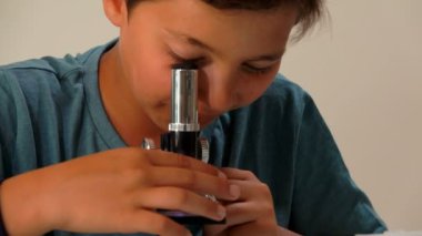 Çocuk mikroskobun merceği alır