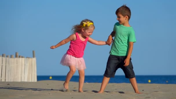 Junge und Mädchen spielen am Strand — Stockvideo