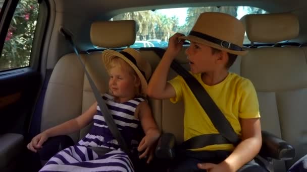 Niño y niña montando en el coche — Vídeos de Stock