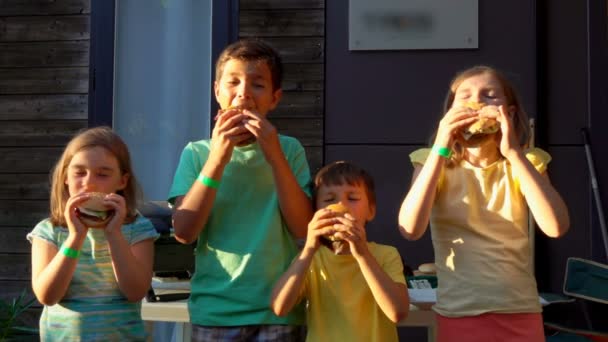 Kinderen eten hamburgers. — Stockvideo