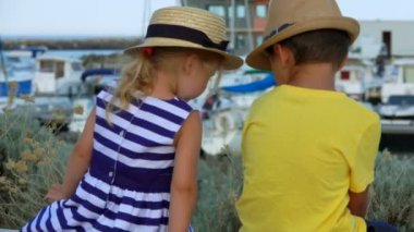 Kız çocuğun yanında bir bankta oturur