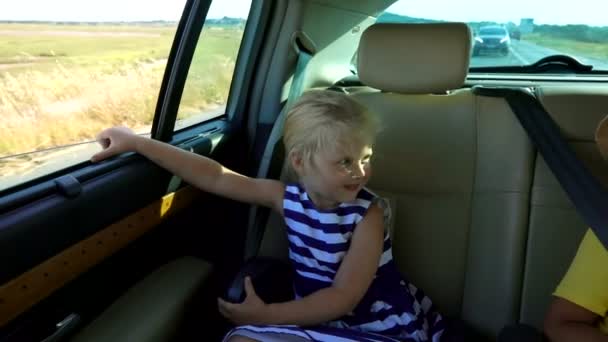 Niño y niña montando en el coche — Vídeos de Stock