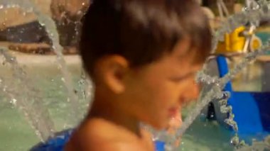 küçük kız su çeşmesi ile oynar