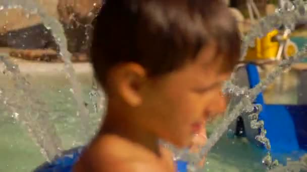 Little girl plays with a fountain of water — Stock Video