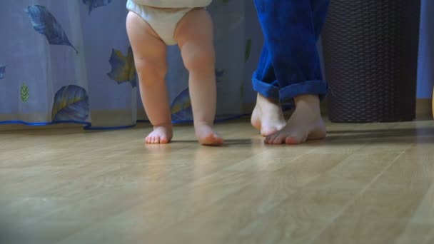 Крупный план детских ног, делающих первые шаги — стоковое видео