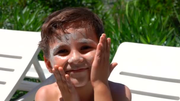 Kleiner Junge mit Sonnencreme beschmiert — Stockvideo