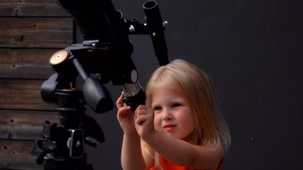 Маленькая девочка смотрит на небо через телескоп — стоковое видео