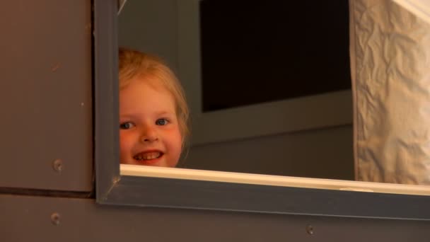 Girl looks out of the open window — Stock Video