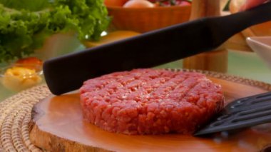Cook göğsü hamburger için iki spatula ile yükseltir.