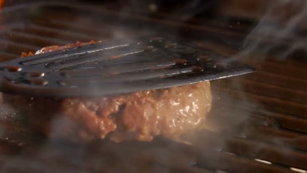 Бургер нажата кухонной лопаткой на гриль — стоковое видео