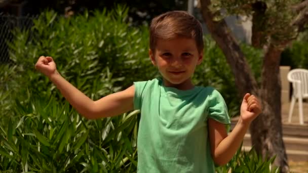 Хлопчик показує м'язи — стокове відео