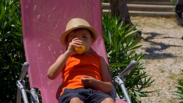 Mamma dà a suo figlio un bicchiere di succo d'arancia . — Video Stock
