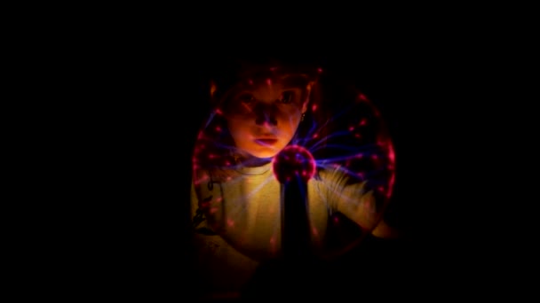 Серйозна дівчина розглядає лампу Тесла — стокове відео