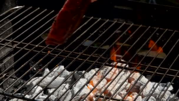 Bucătarul pune friptură folosind tongs pe grătar — Videoclip de stoc