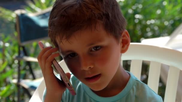 Bruin-eyed jongen luistert naar de telefoon — Stockvideo