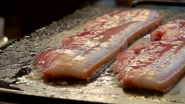 Dos tiras de tocino crudo se tuestan de la parrilla — Vídeos de Stock