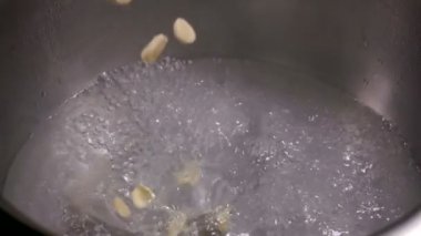 İnce doğranmış sarımsak kaynar suya düşer