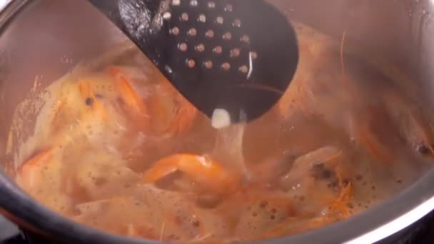 Хозяйка смешивает креветки в кипящей воде — стоковое видео