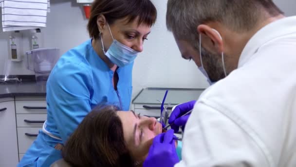 Стоматолог осматривает полость рта пациентов — стоковое видео