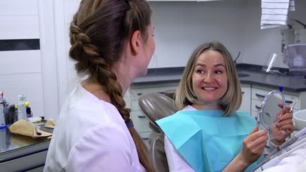 Patient blickt in den Spiegel bei der Zahnarztarbeit — Stockvideo