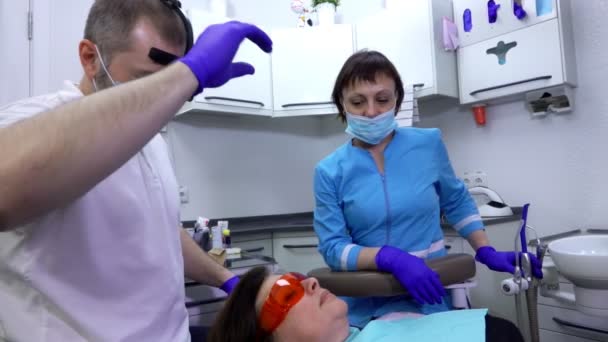 歯科医は患者の歯を治す準備をしている — ストック動画