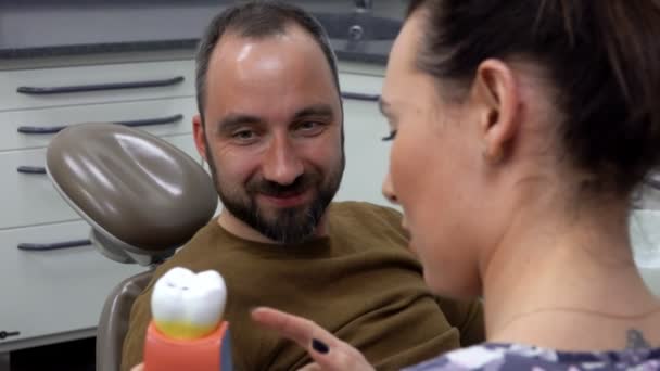 Zubař řekne pacientovi svůj problém na modelu zubu — Stock video