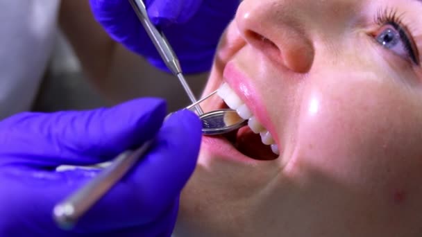 Руки, що обстежують зуби пацієнтів за допомогою зубних інструментів — стокове відео