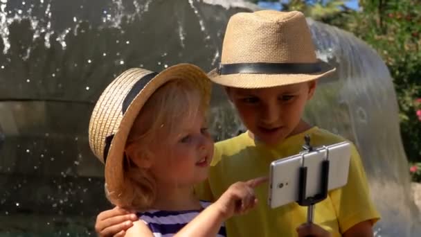 Garçon et une fille prennent une photo selfie à la fontaine — Video