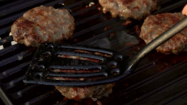 Sabrosas hamburguesas de carne volteando en la parrilla . — Vídeos de Stock