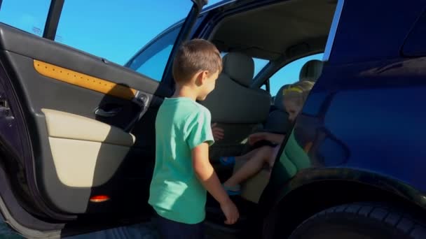 Pequeño niño da una mano a una chica — Vídeos de Stock