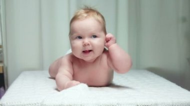 Küçük mutlu bebek karnına yatıyor