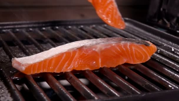 Cook pone el segundo trozo de salmón en la parrilla — Vídeo de stock