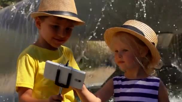 분수대에서 셀카 사진을 찍는 소년과 소녀 — 비디오