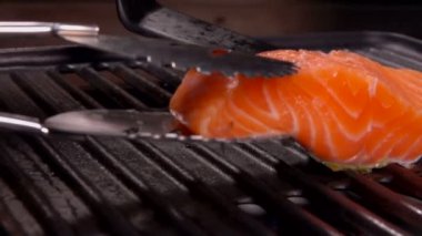 Cook Çiğ somon fileto ızgara ızgara koyar.