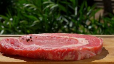 Baharat düşüyor domuz biftek ahşap oyun tahtası üzerinde