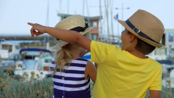 Niño muestra a la chica un yate en la distancia — Vídeos de Stock