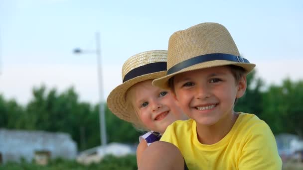 Boy and girl in hats are smiling at the camera — Stock Video