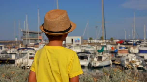 Petit garçon regarde sur le port de yacht — Video