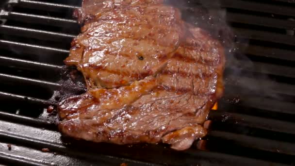 Rook stijgt boven de biefstuk op een hete grill. — Stockvideo