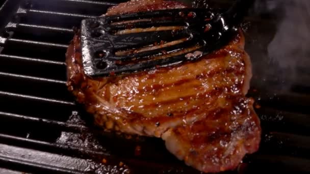 Szakács megnyomja a húst a grill rács — Stock videók